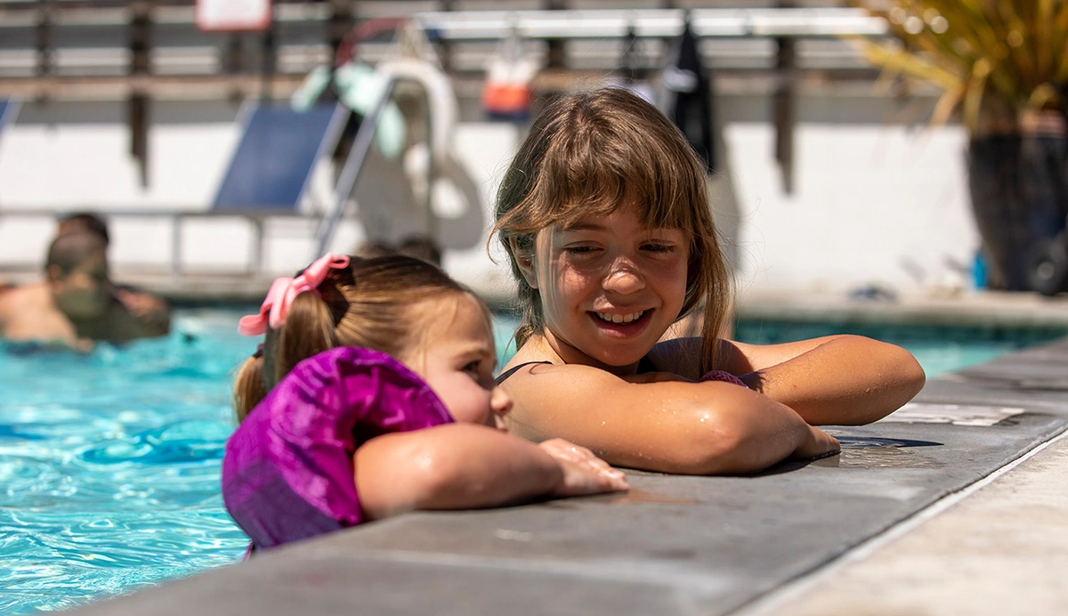 Two children on the edge of a swimming pool