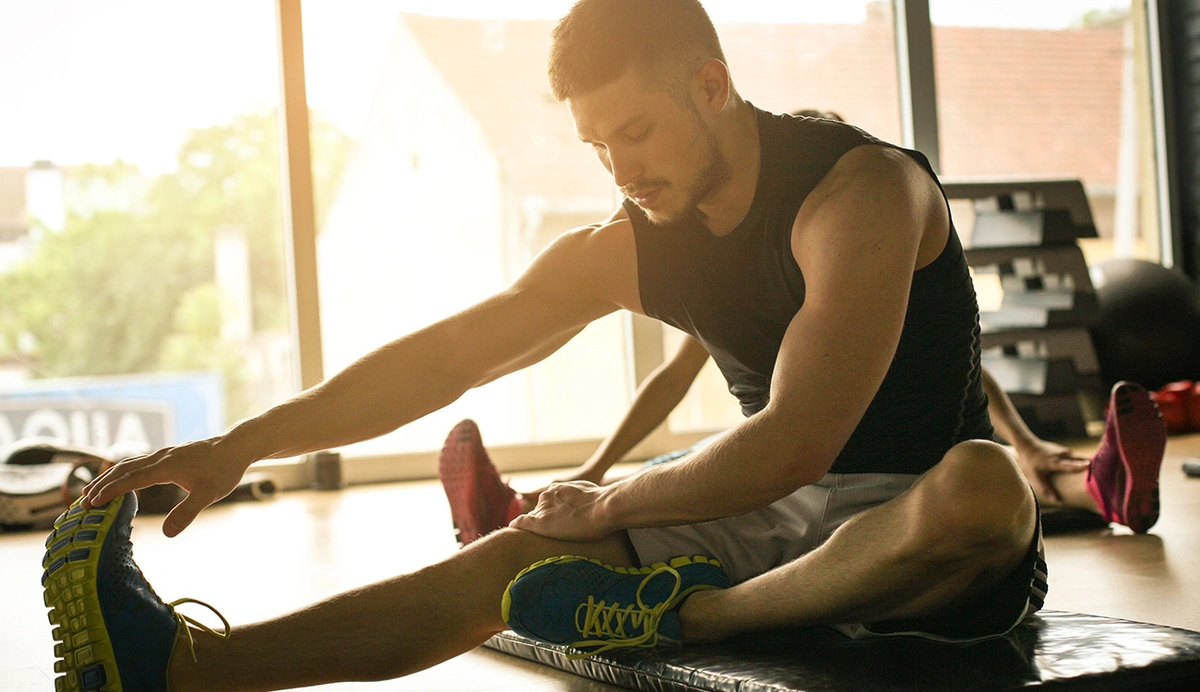 man stretching hamstring on the ground